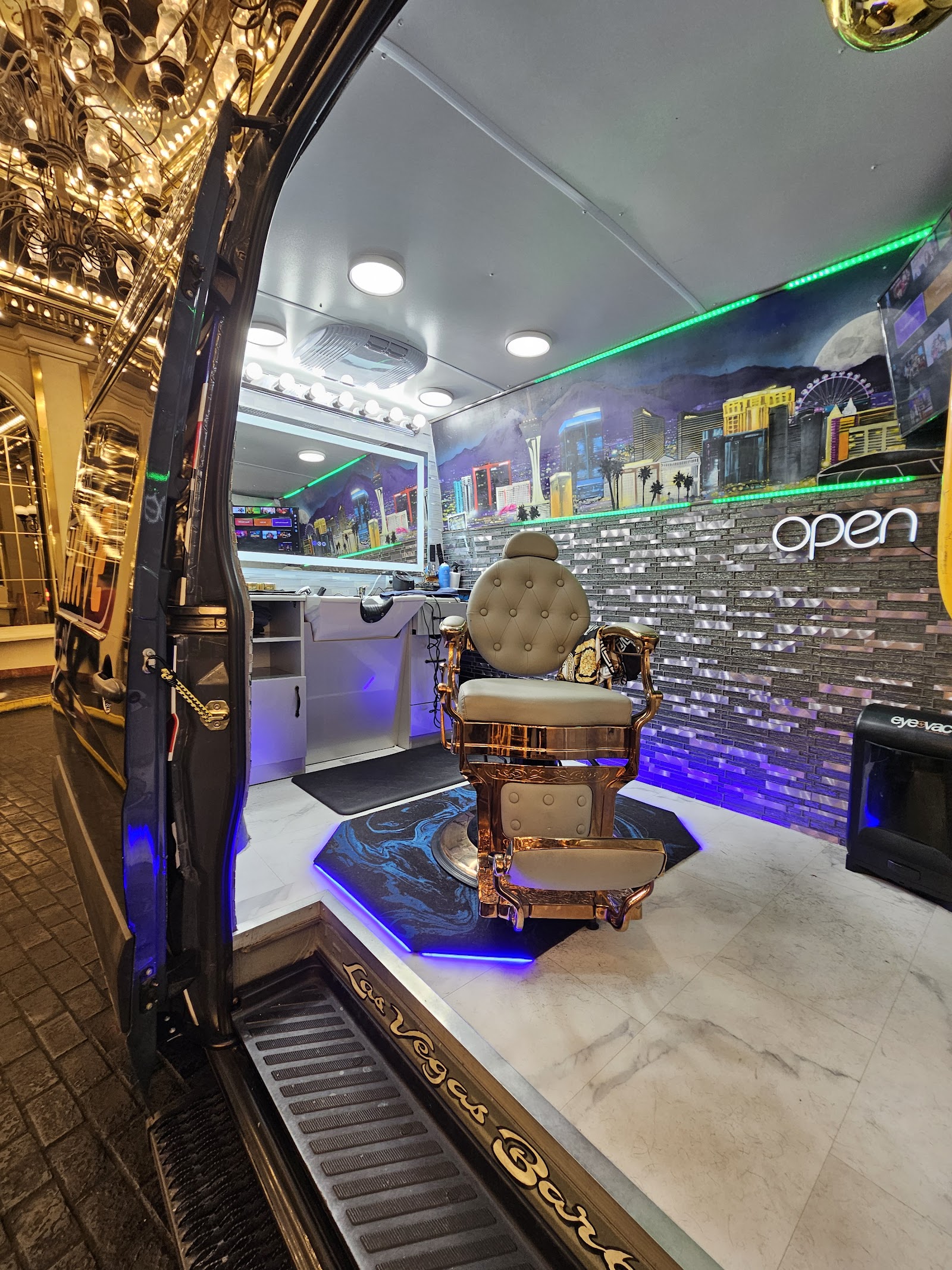 Interior of the luxury mobile barbershop van with a gold barber chair and a Las Vegas skyline mural
