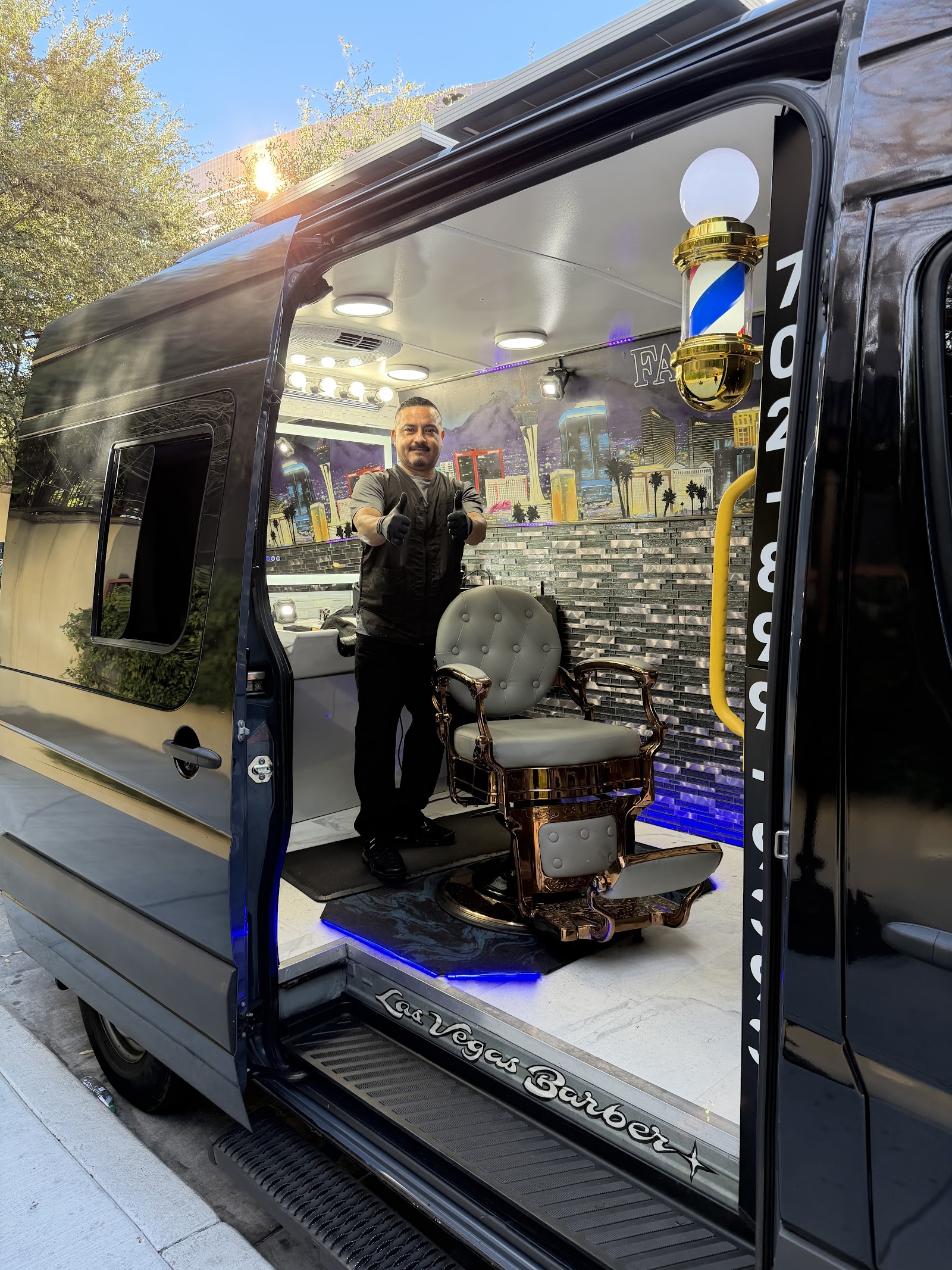 Barber giving a thumbs up inside the mobile barbershop van in daylight